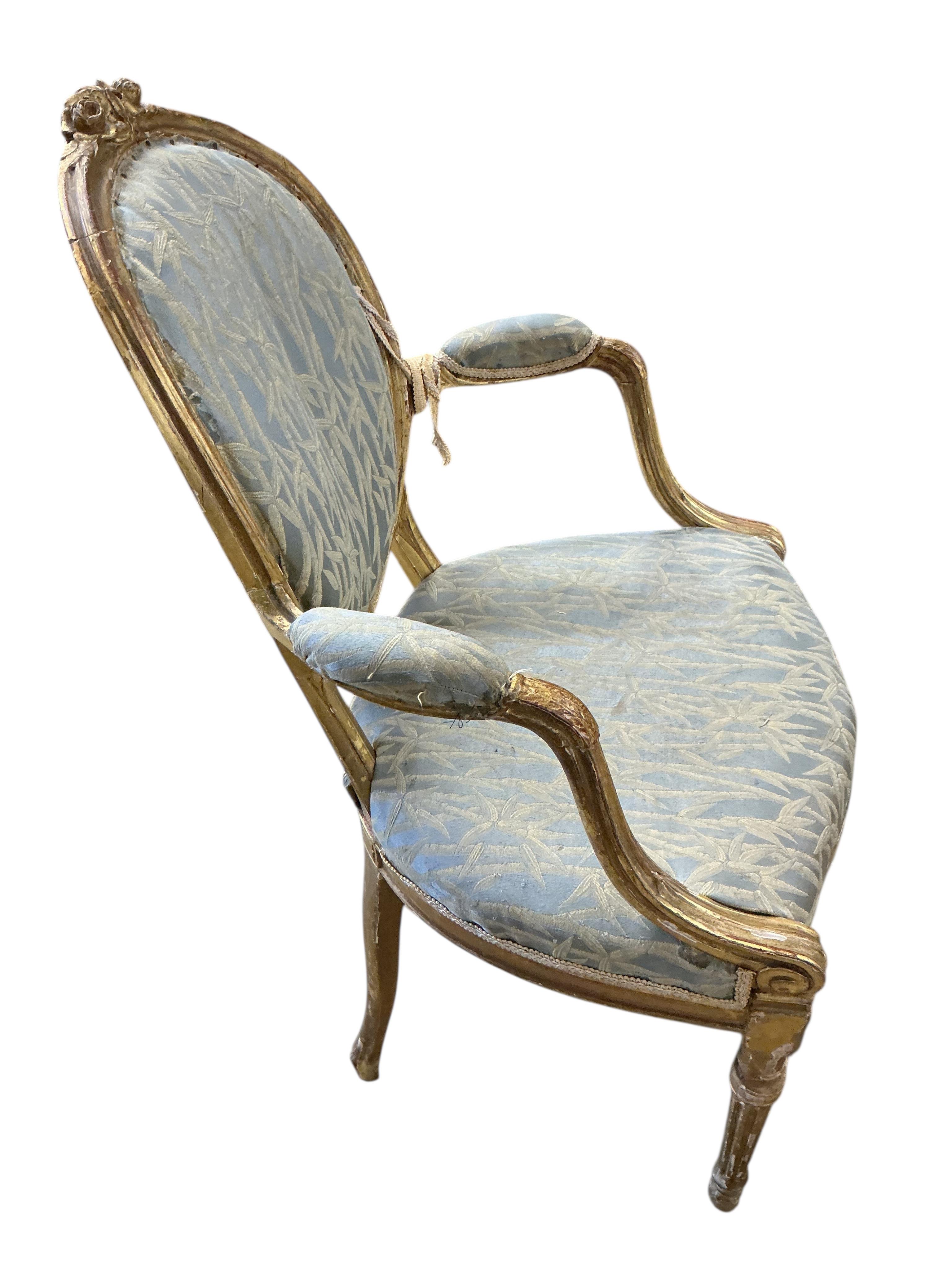 A pair of 18th century carved giltwood open elbow chairs
